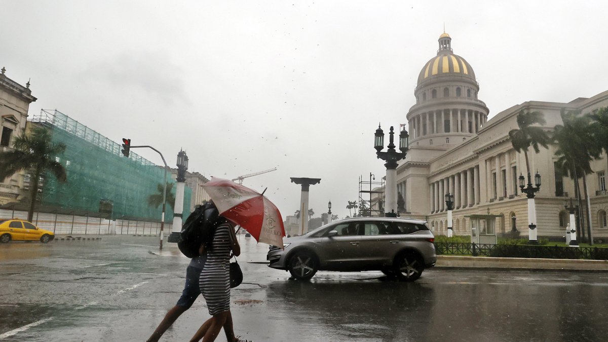 Dos personas caminan bajo la lluvia en la Habana.