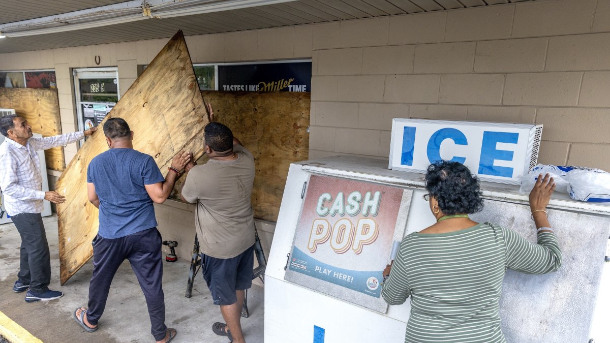 La gente cubre las ventanas con madera contrachapada mientras la ciudad se prepara para el huracán Helene en Mayo, Florida, EE. UU., 26 de septiembre de 2024.