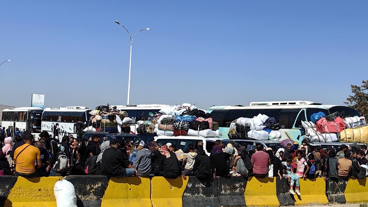 Desplazados libaneses que huyen de los bombardeos esperan en la frontera con Siria.
