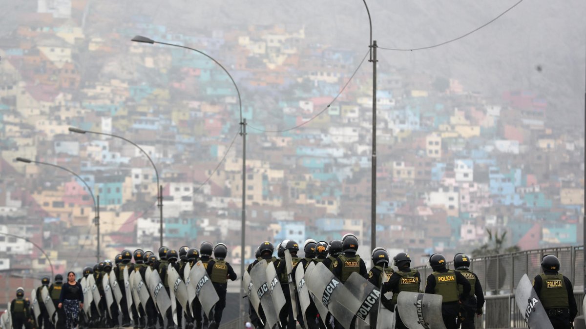 Policías resguardan una vía durante una manifestación de transportistas este jueves en Lima (Perú).
