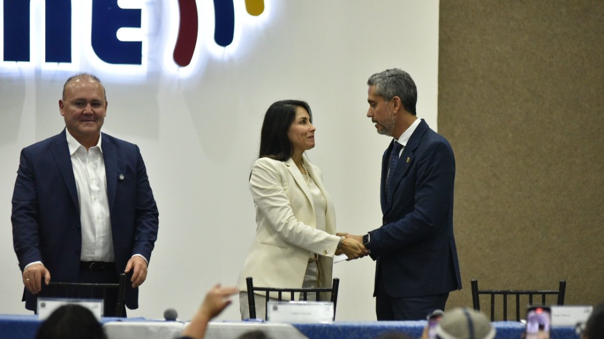 Luisa González y Raúl Chávez estrechándose la mano.