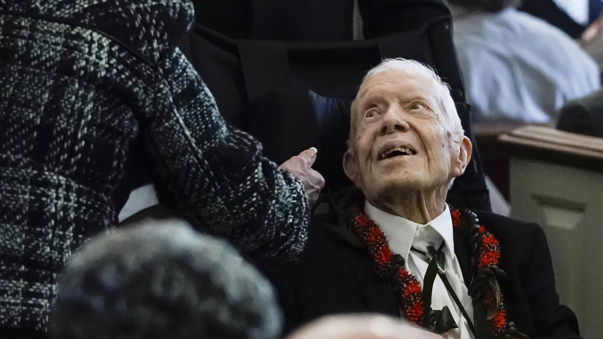 El expresidente Jimmy Carter saludando a algunas personas a la salida del funeral de su esposa, la ex primera dama Rosalynn Carter.