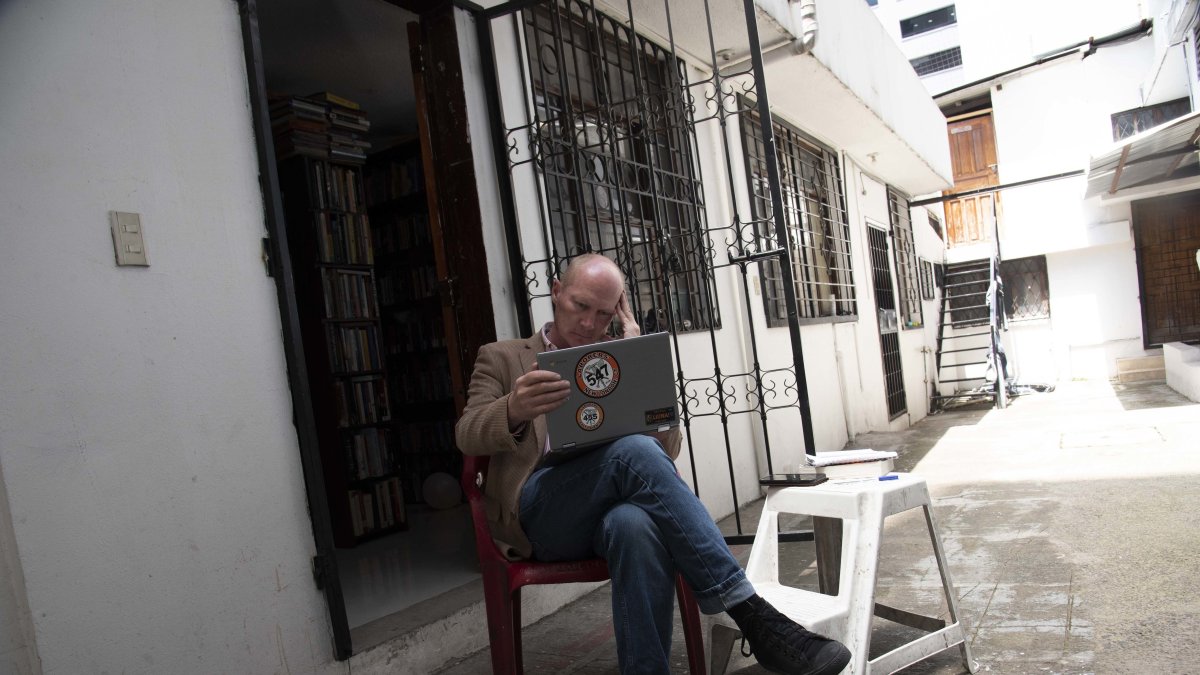 Justin Trudinger sale al patio de su casa buscando una mejor conexión de internet.