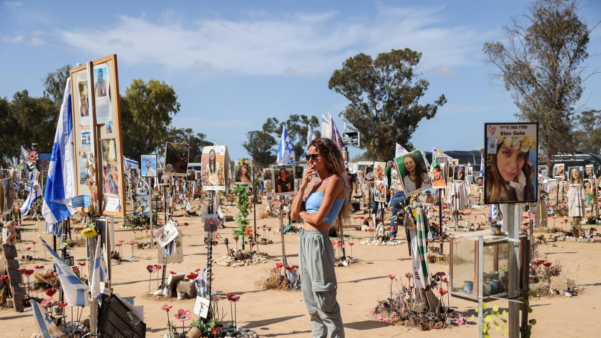 Una mujer mira fotografías y monumentos conmemorativos de los asistentes al festival israelíes que fueron asesinados por Hamas cerca del Kibbutz Reim, en el sur de Israe.