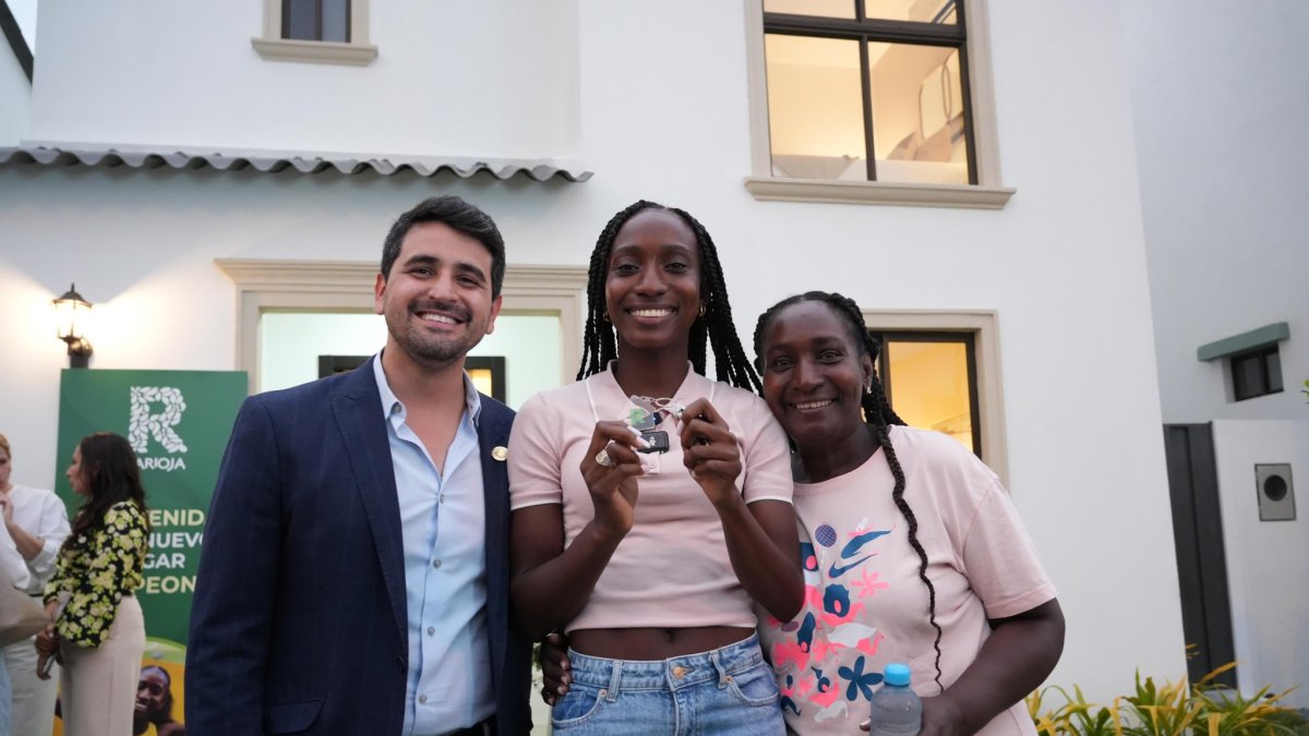 Kiara (c) junto a su madre y el ministro de vivienda, Humberto Plaza, durante la entrega.