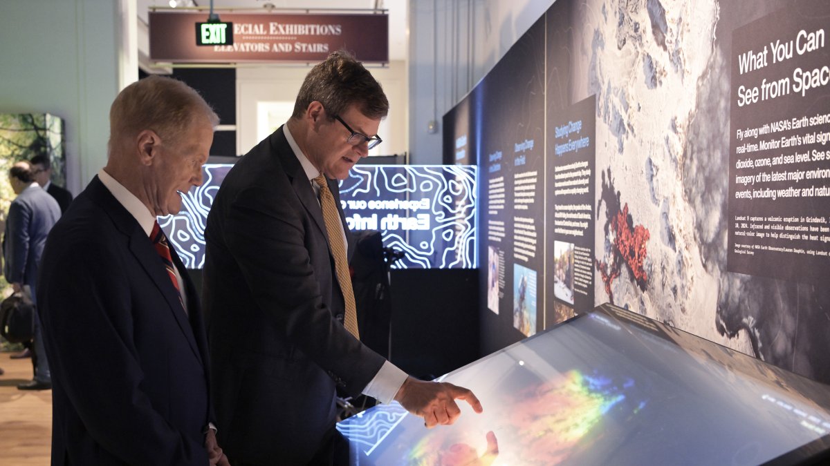 El administrador de la NASA, Bill Nelson (i), y el director del Museo Nacional de Historia Natural, Kirk Johnson, visitan la exposición.