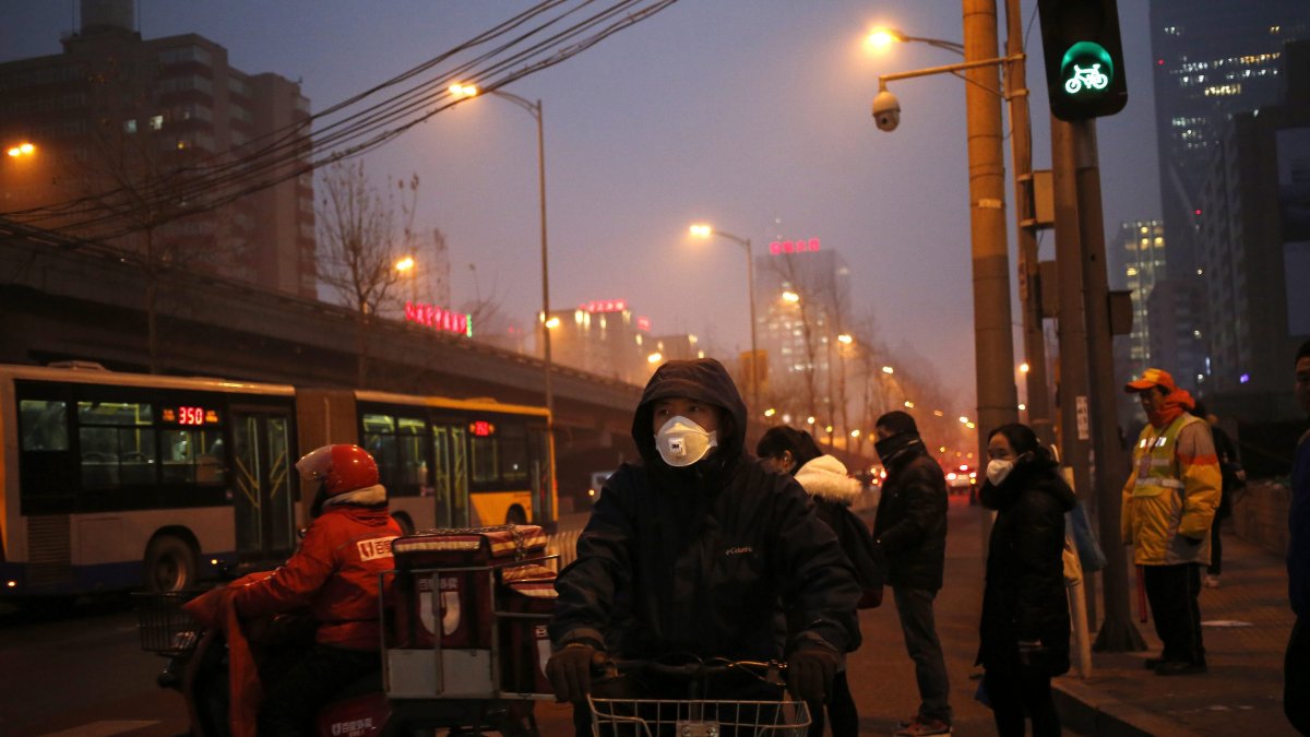 En la imagen de archivo, peatones utilizan mascarillas para protegerse de la contaminación en Pekín (China).