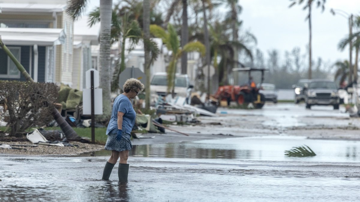Una mujer camina por una calle inundada tras el paso del huracán Milton en Bradenton, Florida.
