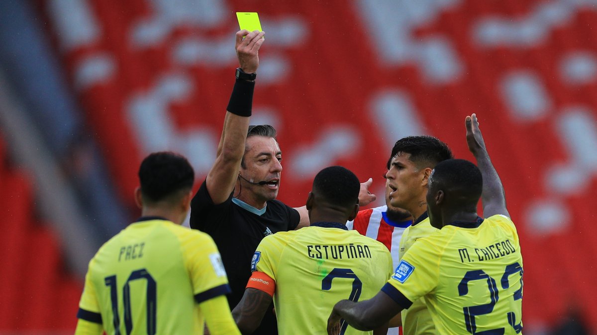 Jugadores de Ecuador discuten con el árbitro Raphael Claus una tarjeta amarilla para Pervis Estupiñán (c) en el partido Ecuador vs Paraguay