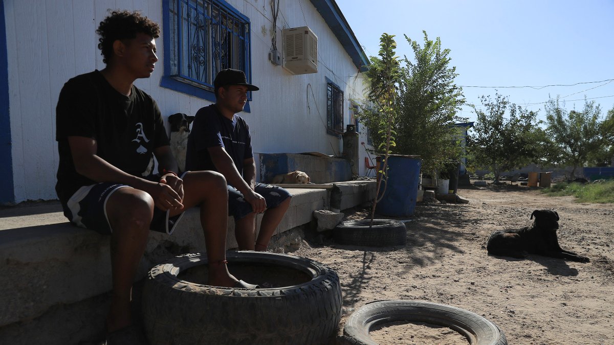 Ángel Landino (i) y Fabián Rodríguez de Honduras descansan, en espera de resolver su situación migratoria, en un albergue este jueves, en Ciudad Juárez