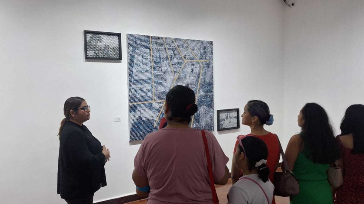 El recorrido en la sala de exhibición de las pinturas es guia por la artista. (der.)