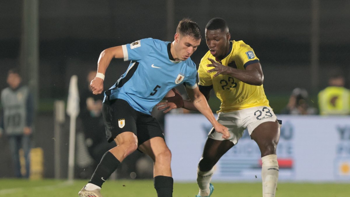 Manuel Ugarte de Uruguay disputa un balón con Moisés Caicedo de Ecuador en Montevideo.