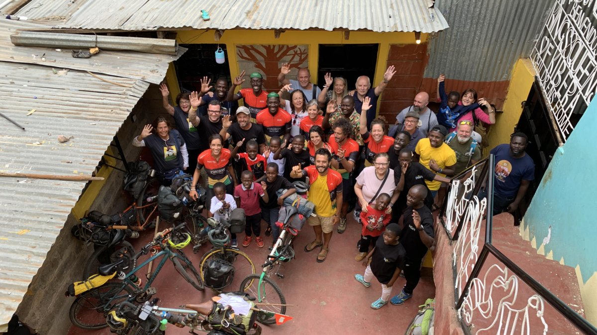 Grupo de la caravana de bicicletas después de llegar a Kibera, un asentamiento informal situado en Nairobi, junto a familiares y amigos en la casa de la ONG Kings and Queens of Kibera.