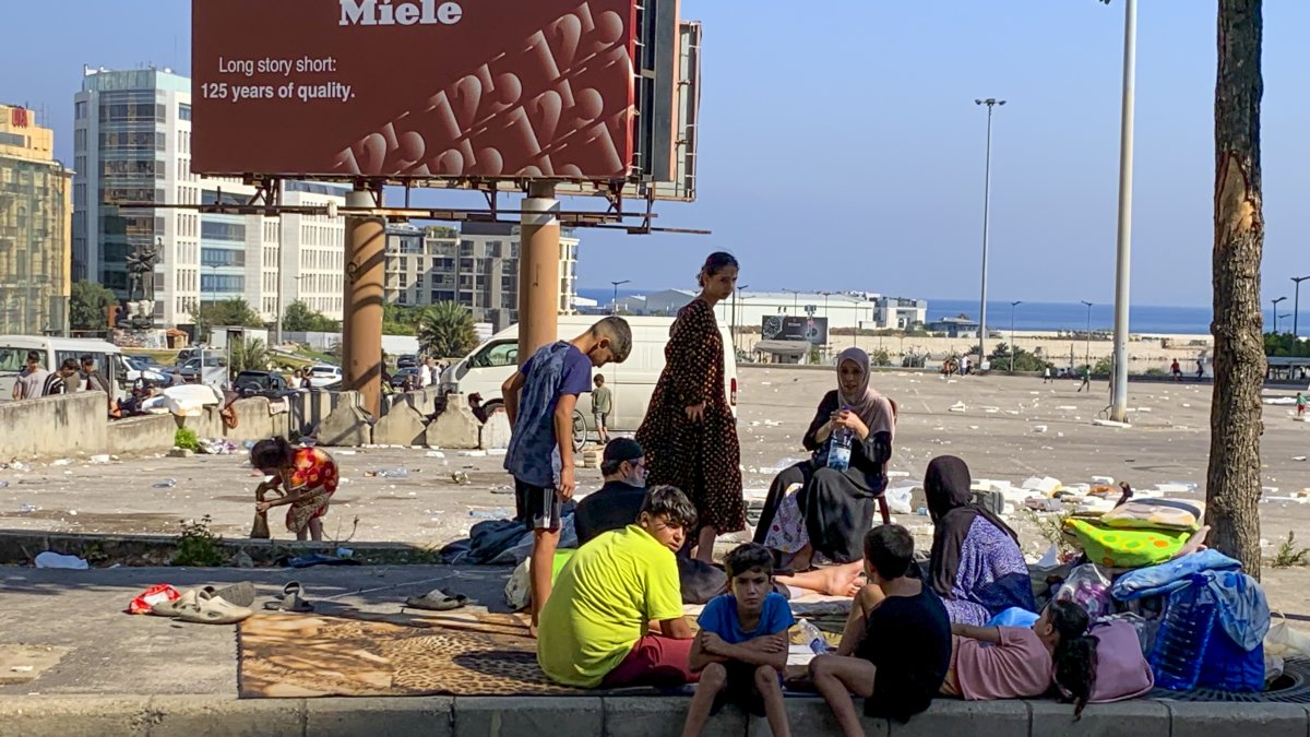Una familia de desplazados acampa en una plaza de Beirut tras huir de bombardeos israelíes en los suburbios sur de la capital.