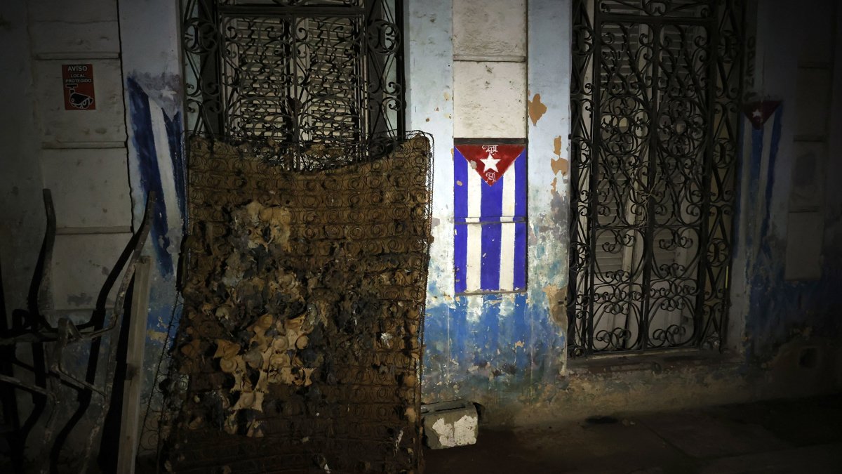 Fotografía de un colchón dañado junto a una bandera de Cuba durante un apagón este viernes, en La Habana.