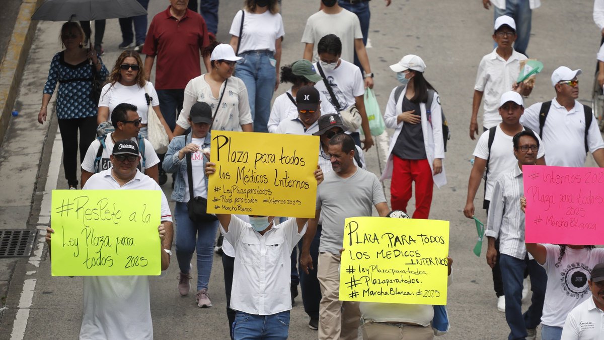 Manifestantes sostienen carteles en una marcha este sábado 19 de octubre en San Salvador (El Salvador).