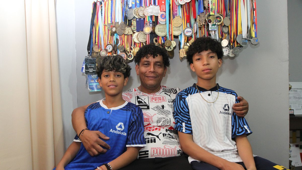 Boris Villavicencio (c) muestra con orgullo las medallas que han ganado sus hijos Boris Néstor (i) y Boris Jeriel (d).