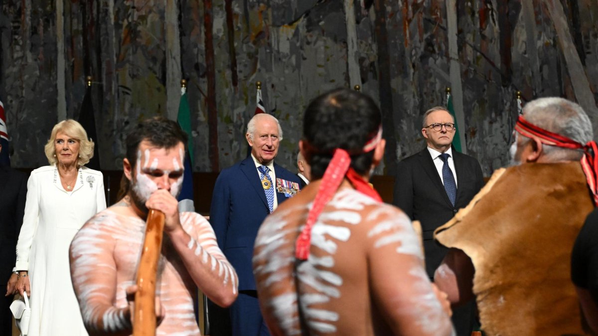 El rey Carlos III de Gran Bretaña (centro) y la reina Camila (izquierda) observan a bailarines aborígenes mientras, en su visita a Australia.