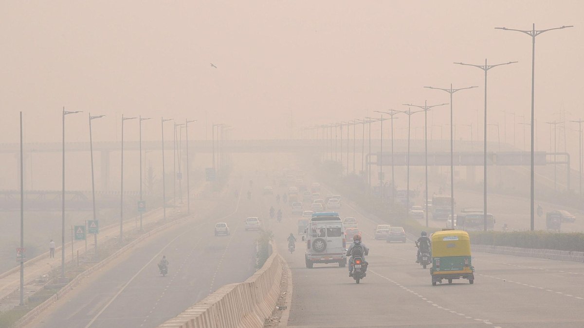 Vehículos circulan entre la niebla mezclada con humo en Nueva Delhi, la India, en una imagen de archivo.