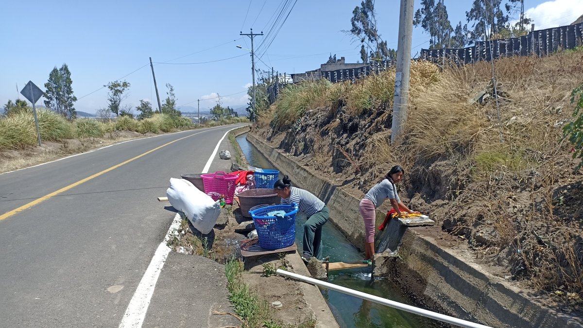 Vías. Mujeres son vistas lavando ropa al borde de las carreteras.