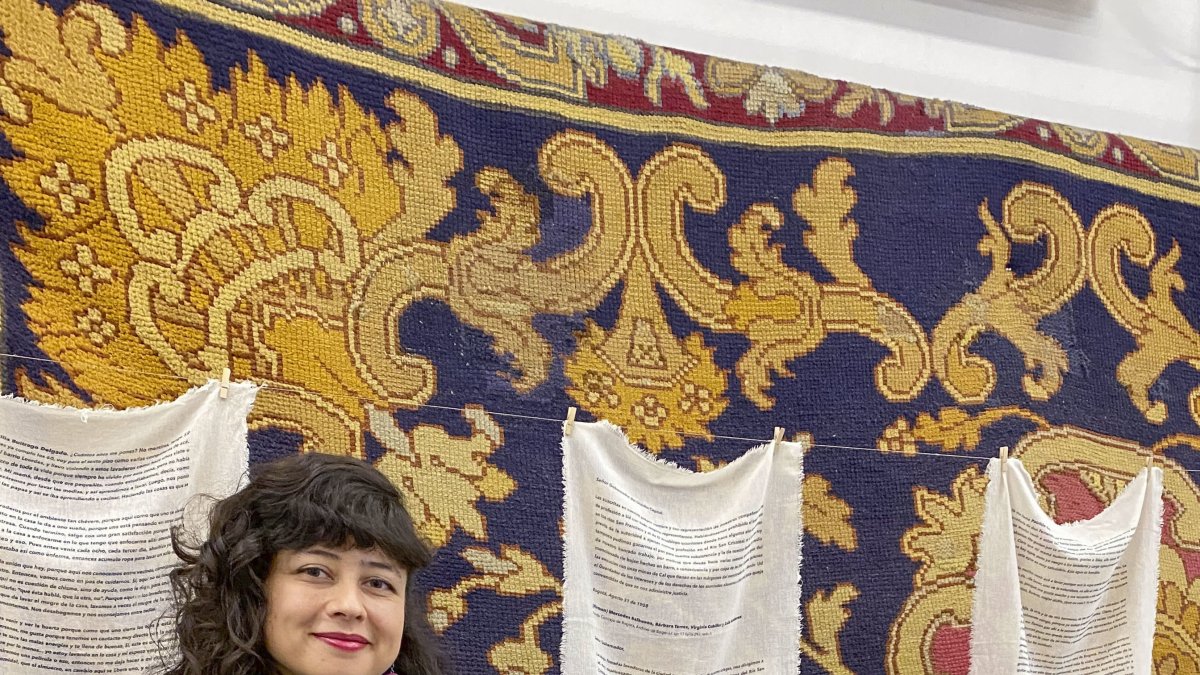 La artista colombiana Vanessa Nieto posa junto a una de sus obras expuestas en la Real Fábrica de Tapices.