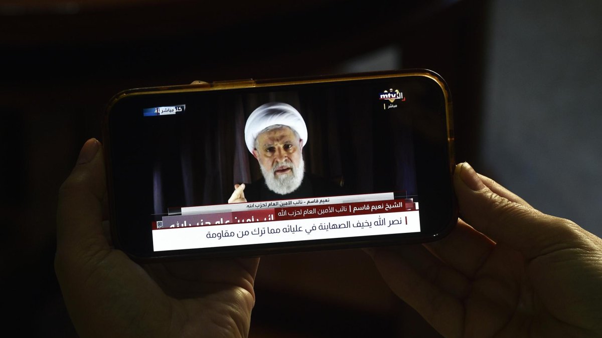 Una persona ve en su teléfono móvil un discurso de Naim Qassem transmitido por el canal de televisión Al-Manar de Hizbulá, en Beirut, Líbano, el 08 de octubre de 2024.