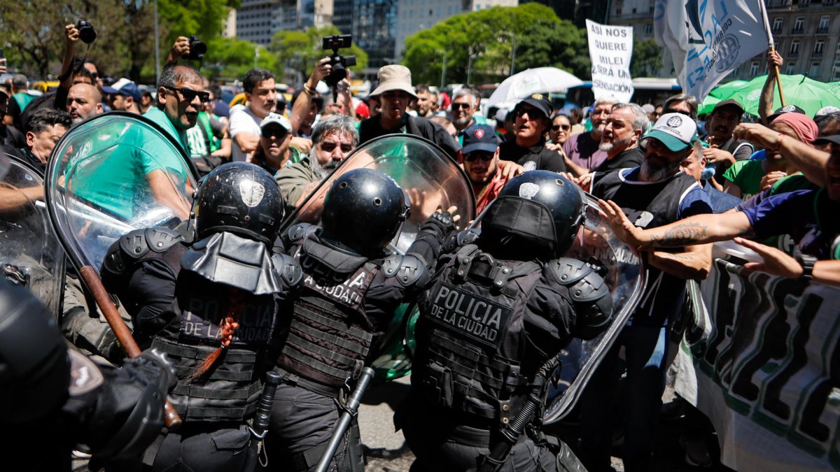 Un grupo de personas se enfrenta a la policía durante una marcha de miembros de la Asociación Trabajadores del Estado (ATE), este martes, en Buenos Aires (Argentina).