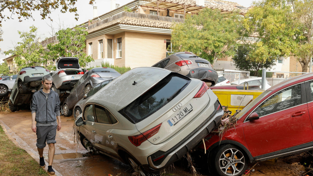 Un hombre camina junto a varios vehículos afectados por las intensas lluvias de la fuerte DANA que afecta especialmente el sur y el este de la península ibérica.