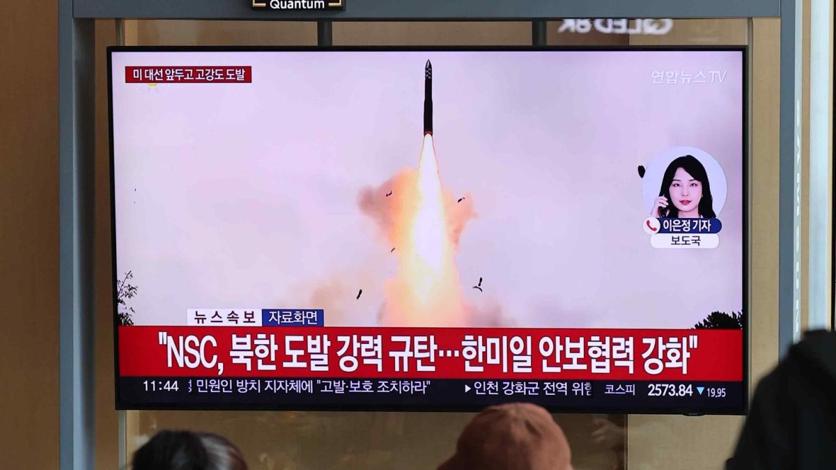 Varias personas ven las noticias sobre el lanzamiento por parte de Corea del Norte de un nuevo misil balístico intercontinental de combustible sólido en la estación de Seúl.