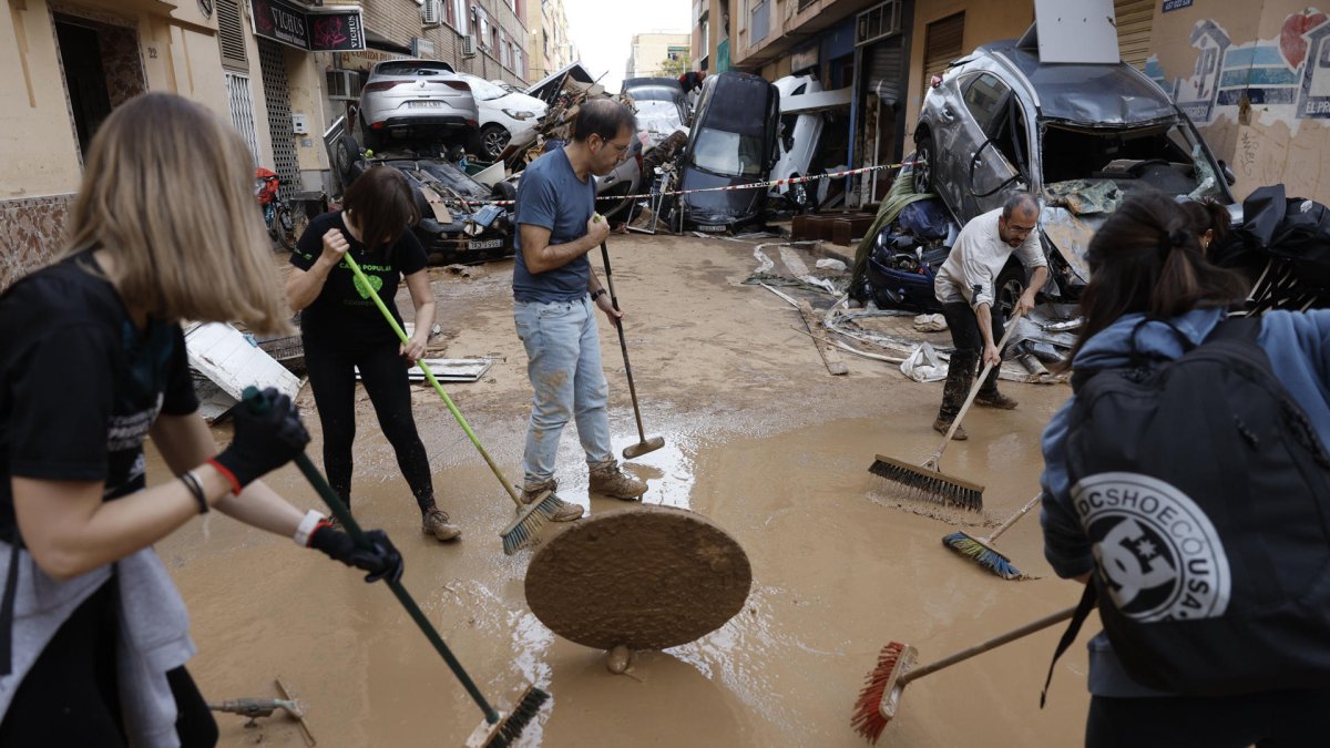 Vecino y personas de diversas comunidades autónomas trabajan como voluntarios para restablecer la normalidad en Alfafar (Valencia), este viernes.