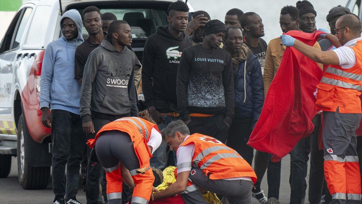 Un inmigrante es atendido a su llegada al puerto de Arrecife en Lanzarote entre un grupo de personas que intentaban llegar a las costas canarias, este domingo 3 de noviembre.