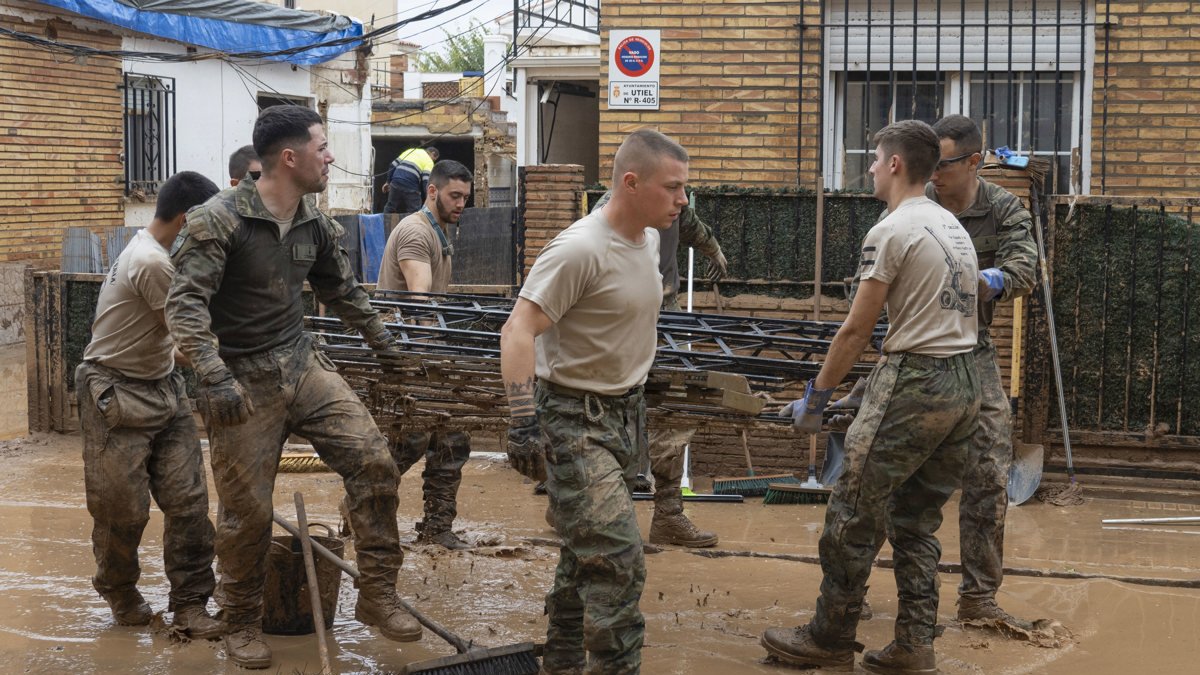 Miembros del Ejército de Tierra limpia las calles tras el paso de la dana, este lunes 4 de noviembre en Utiel, Valencia.