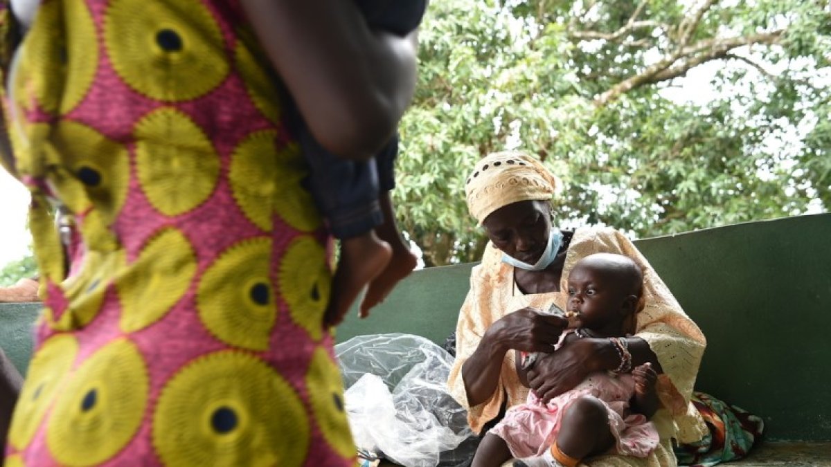 Una mujer da de comer a su nieta con tuberculosis en un centro médico en Sierra Leona.