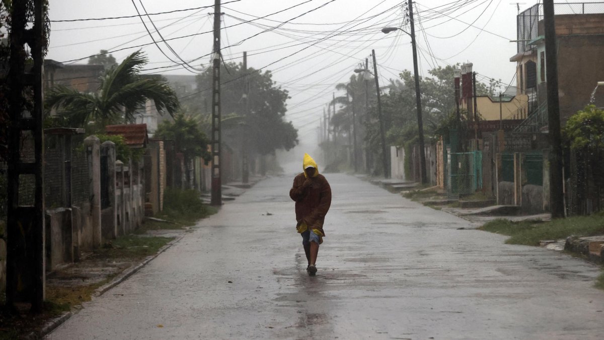 Un hombre camina en medio de la lluvia debido al paso del huracán Rafael, este miércoles, en La Habana (Cuba).