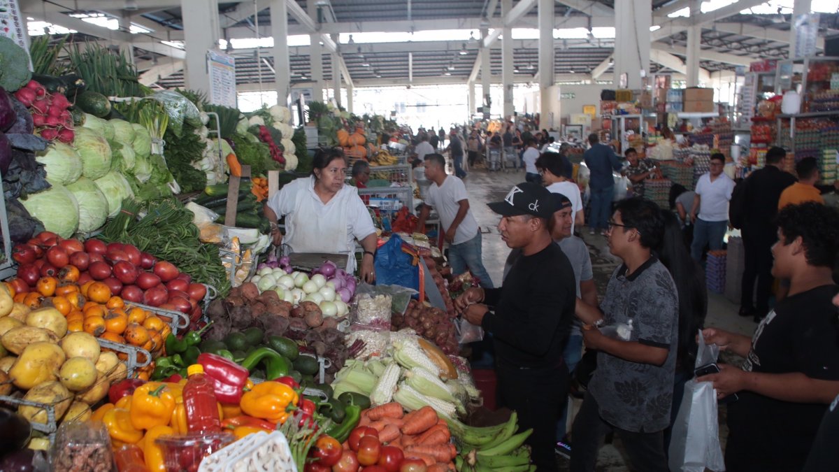 Mercado. Un grupo de personas realizan las compras de los alimentos.
