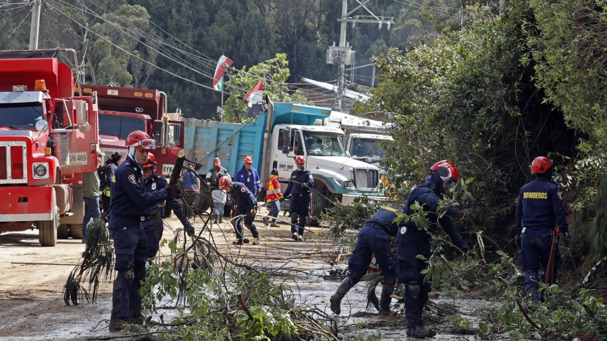 Trabajadores que recogen escombros tras afectaciones por la temporada de lluvias en Colombia.