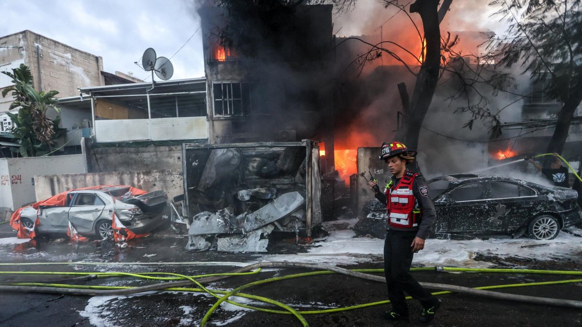 Los bomberos israelíes trabajan para extinguir un incendio después de que cohetes disparados desde Líbano impactaran en la ciudad de Kiryat Ata, distrito de Haifa.