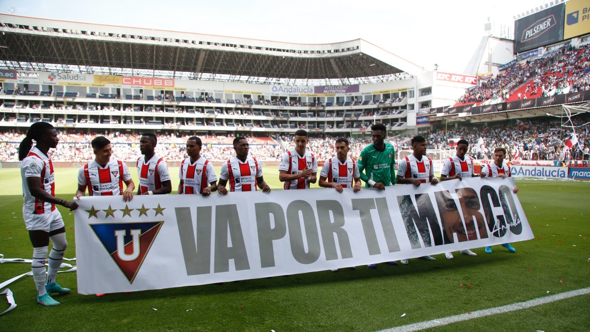 Los jugadores de Liga de Quito saltaban a la cancha con un cartel dedicado a Marco Angulo.