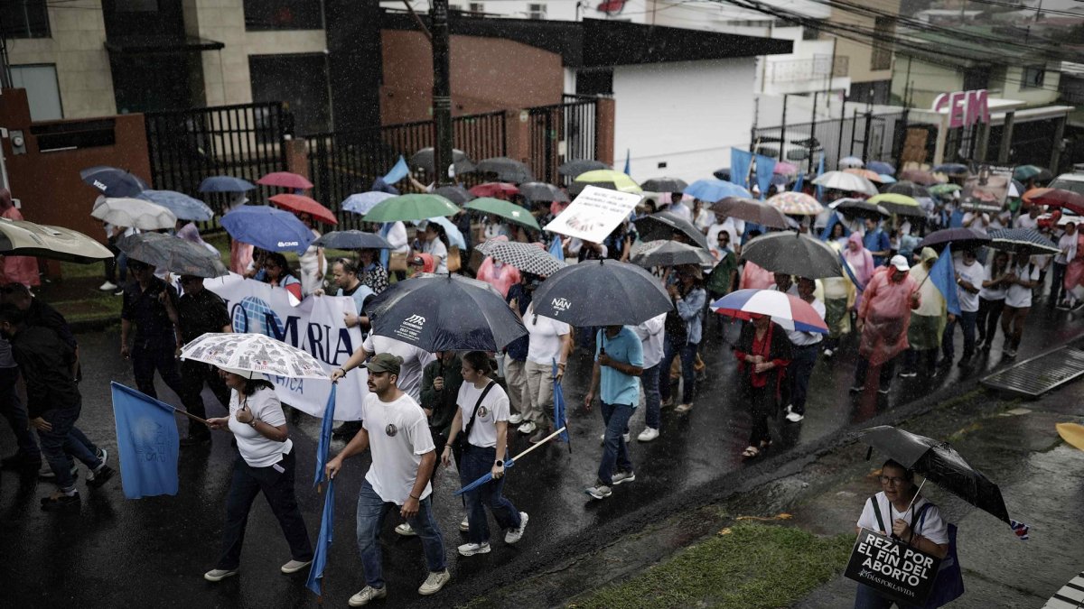 Varias personas se manifiestan en contra del aborto durante una marcha llamada en San José (Costa Rica), en un día con fuertes lluvias.