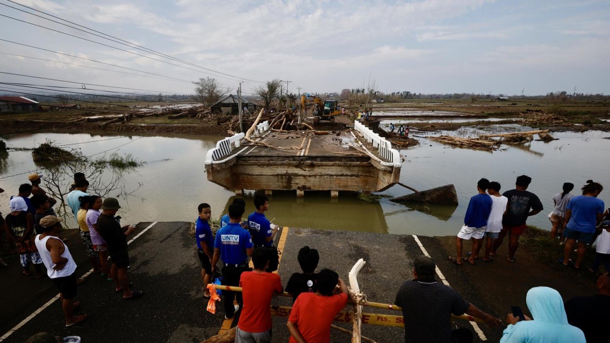 Aldeanos filipinos observan un puente dañado afectado por el tifón Usagi, en el municipio costero de Santa Ana, provincia de Cagayán, Filipinas, el 15 de noviembre de 2024.