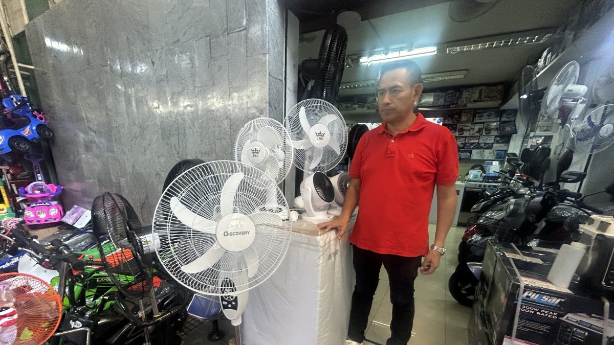 Comerciantes del centro de Guayaquil ofrecen focos y ventiladores recargables.