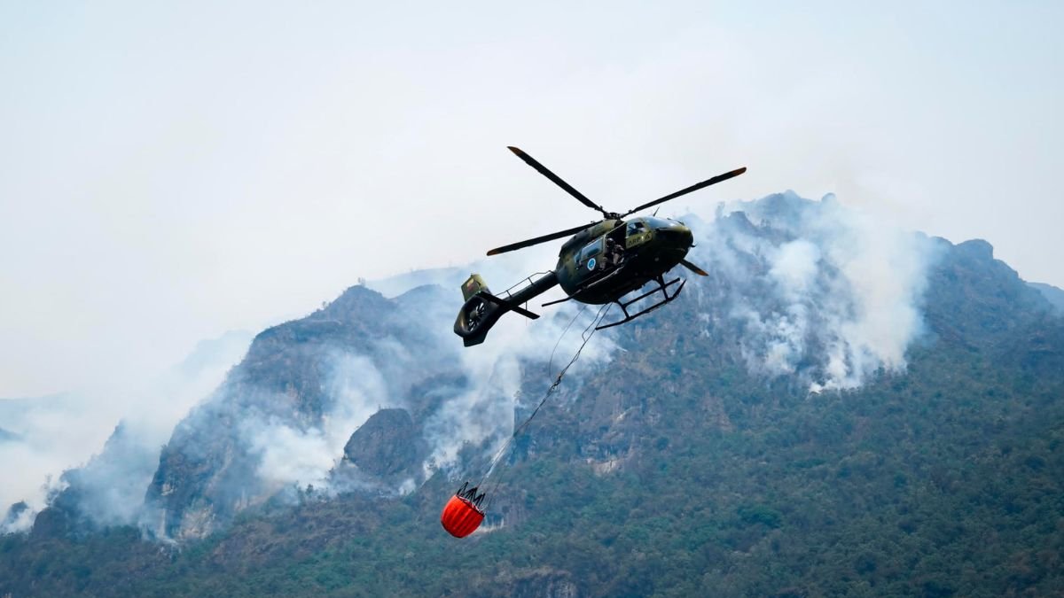 Fotografía cedida por el Cuerpo de Bomberos de Cuenca de un helicóptero combatiendo un incendio forestal en el Parque Nacional Cajas, en Cuenca (Ecuador).