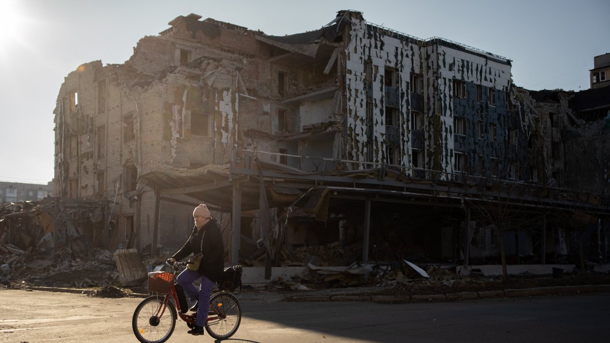 Un residente local pasa en bicicleta por una tienda y un restaurante destruidos en la ciudad de Pokrovsk, región de Donetsk, el 19 de noviembre de 2024.