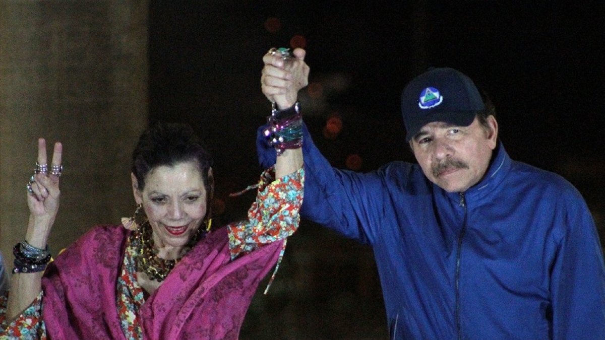 El presidente Daniel Ortega (R), y su esposa, la vicepresidenta Rosario Murillo, hacen un gesto ante la multitud durante la inauguración del paso elevado de Nejapa en Managua.