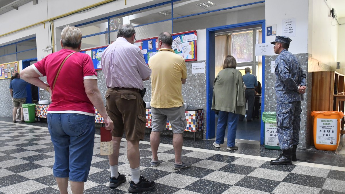Personas hacen fila para votar durante la segunda vuelta de las elecciones presidenciales, este domingo, en Montevideo (Uruguay).