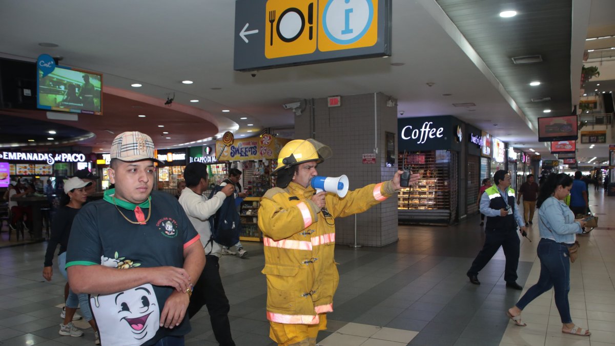 Un guía indica a través, de megáfono, la ruta de evacuación en el Terminal.