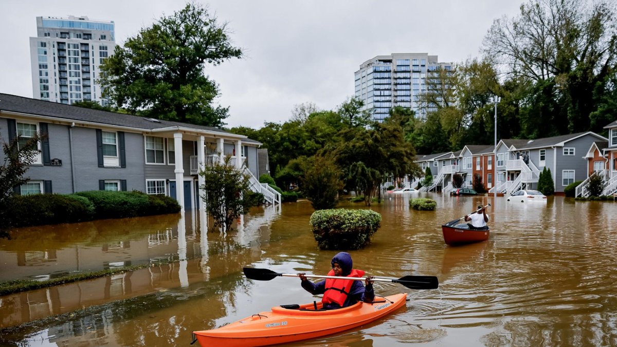 Candice Ocvil (i) y Jibri Tolen (d), residentes de Peachtree Park, remando a través de las aguas de la inundación después de que la tormenta tropical Helene atravesó Atlanta, Georgia (EE.UU.).