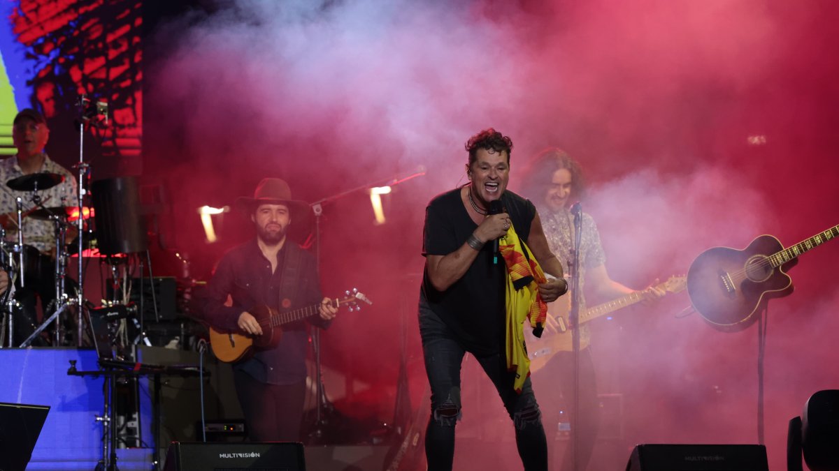 Carlos Vives recibe una camiseta amarilla y la ondea en honor a Ecuador, n el escenario del Guayaquil Country Club.