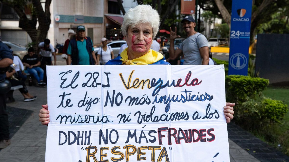 Una mujer sostiene una pancarta durante una vigilia este domingo, en Caracas (Venezuela).