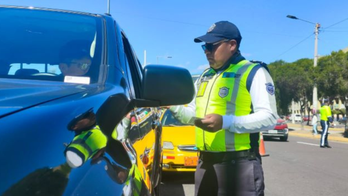 Agente civil de tránsito, en un procedimiento, en una vía en Quito.